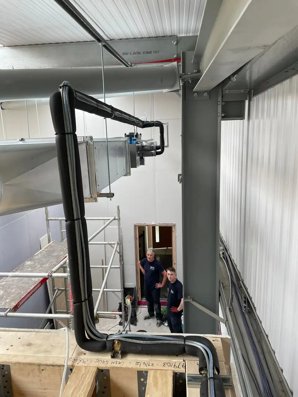 Commercial air conditioning by our Manchester engineers Engineers installing ventilation ductwork in a commercial building